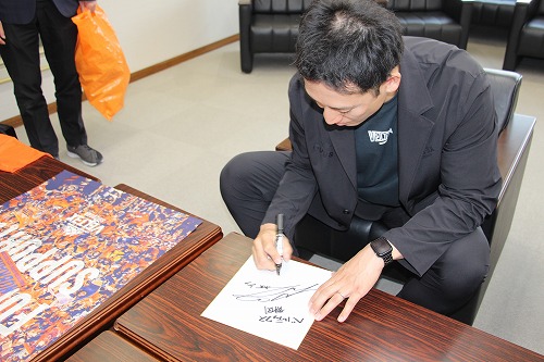 色紙にサインをする加納選手