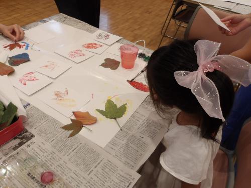 落ち葉に絵の具を塗って絵はがきを作成する様子